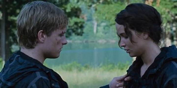 Why does Katniss kiss Peeta on the cheek
